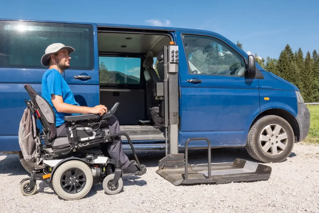 Disabled man in wheelchair sitting next to van