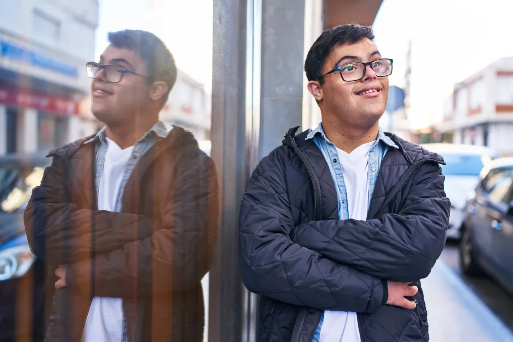 Disabled man outside smiling with arms crossed
