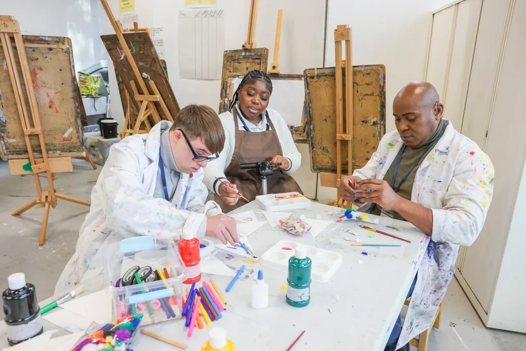 Three diverse disabled friends in art class