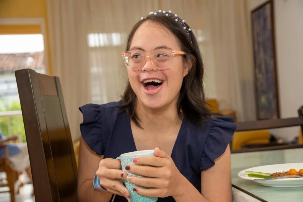 Happy disabled woman smiling while holding cup of tea